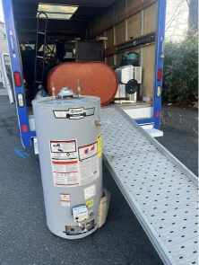 Water heater being loaded onto a truck ramp for appliance removal in Lubbock