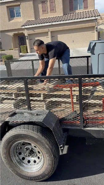Local junk removal crew loading items onto a trailer at a home in Lubbock, Texas