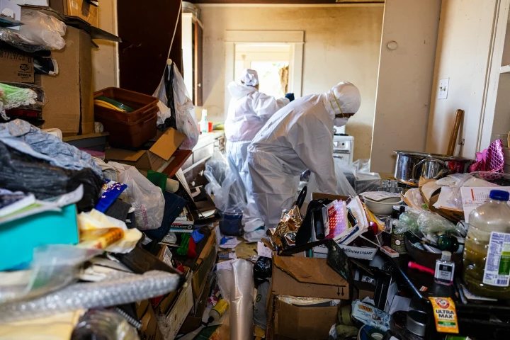 Cleanup crew in protective suits removing clutter during a hoarding cleanup in Lubbock