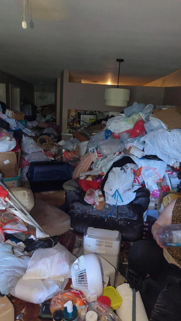 Cluttered room filled with bags and household items before a hoarding cleanup in Lubbock , texas