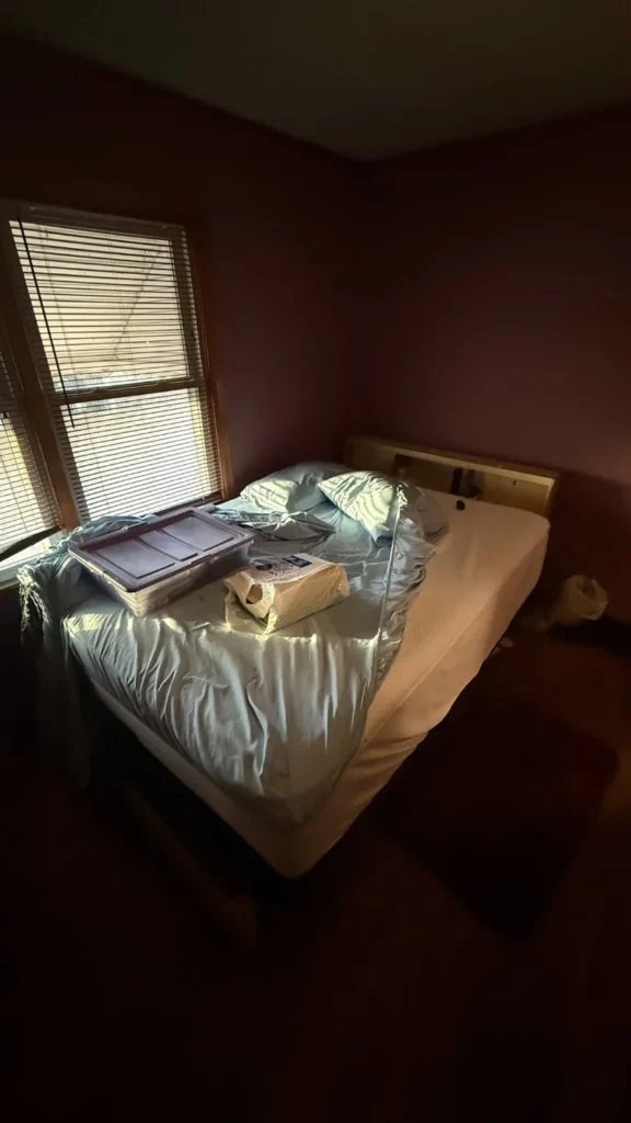 Bedroom with a bed and packed items ready for a cleanout in Lubbock, Texas