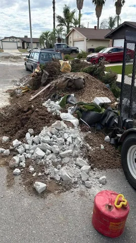 Remodel debris removal Lubbock pile of wood scraps, trim pieces, and bagged waste beside a driveway
