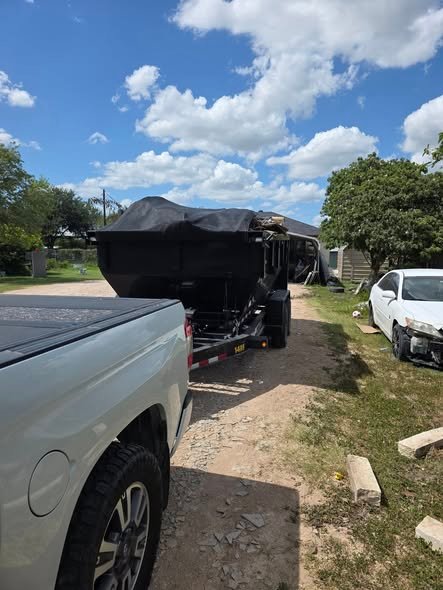 Loaded hauling trailer on a driveway showing how landfill fees drive dumpster pricing for heavy debris